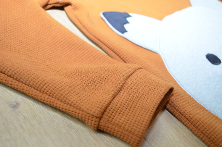 Pullover aus orangem Waffelstrick Jersey mit Wolf Stickmotiv