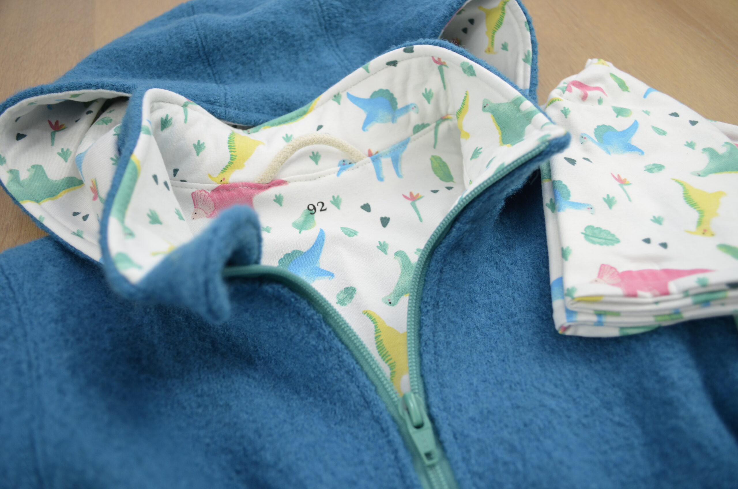 Walkparka, hellblau, Dino auf weißem Hintergrund, Detailfoto